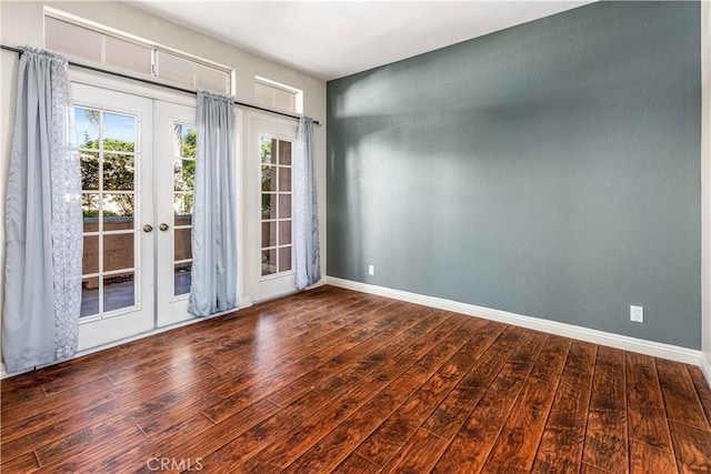 spare room featuring wood-type flooring, baseboards, and french doors