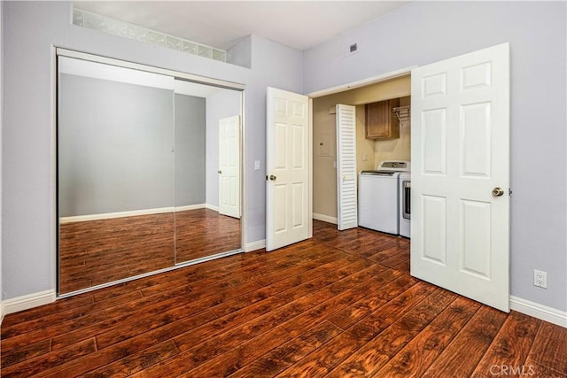 unfurnished bedroom featuring visible vents, baseboards, dark wood-style floors, washer and dryer, and a closet