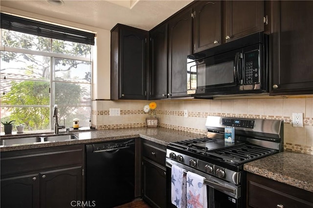 kitchen with black appliances, dark stone countertops, a sink, and decorative backsplash