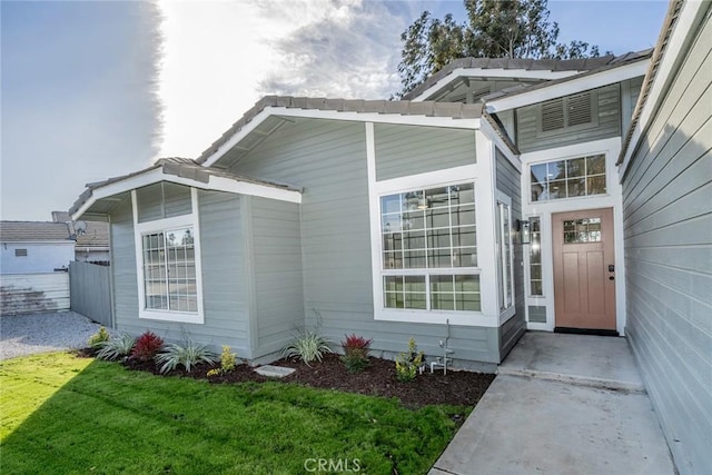 view of exterior entry with a lawn