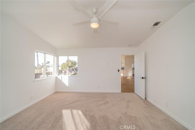 spare room with light carpet, ceiling fan, and vaulted ceiling