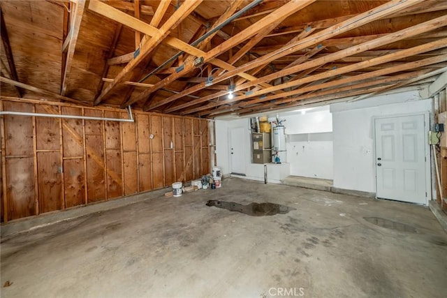 garage with strapped water heater and wood walls