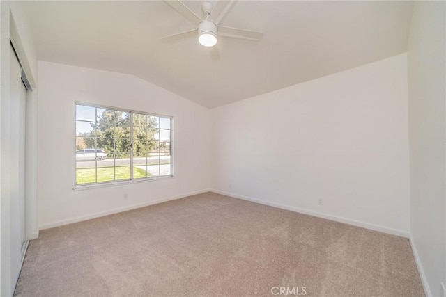 carpeted spare room with lofted ceiling and ceiling fan