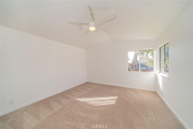 carpeted spare room with ceiling fan and lofted ceiling