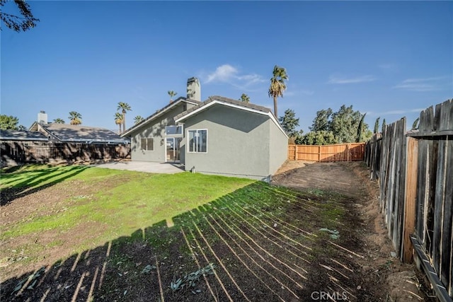 rear view of property with a patio and a yard