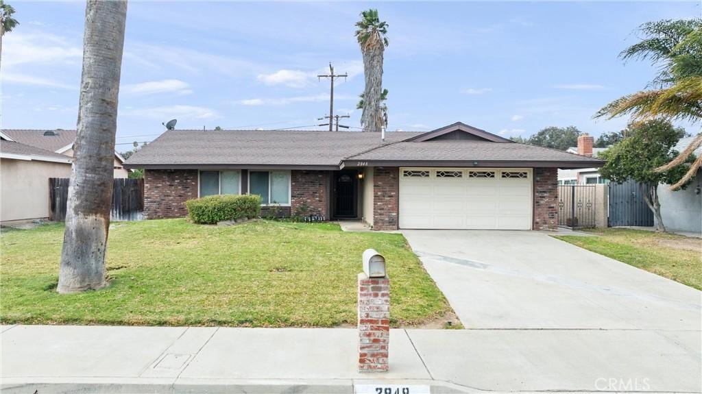 single story home featuring a garage and a front yard