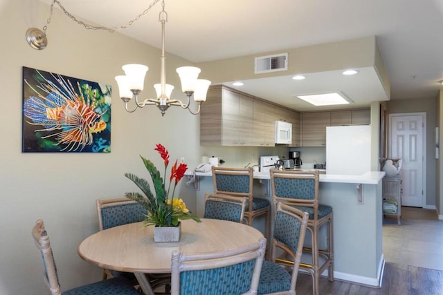 dining area with dark hardwood / wood-style floors and a notable chandelier