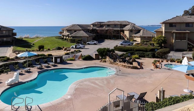 view of swimming pool with a water view and a patio