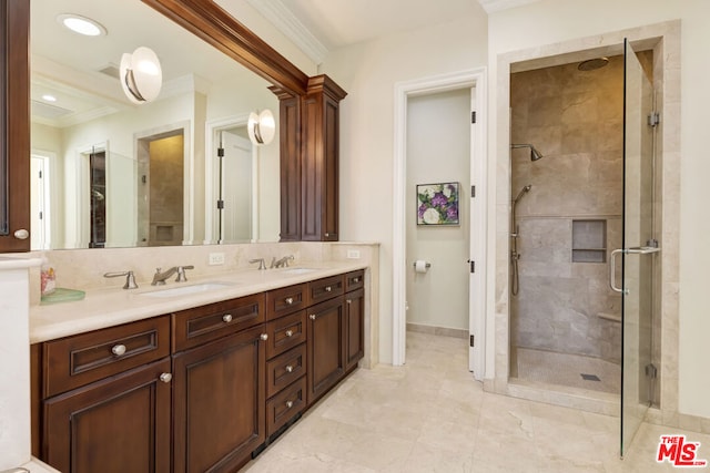 bathroom with vanity, ornamental molding, decorative backsplash, and a shower with door