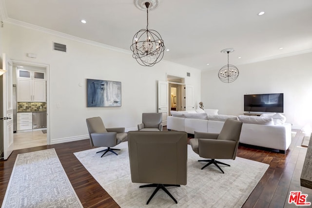 living room featuring dark wood-type flooring, ornamental molding, and a notable chandelier