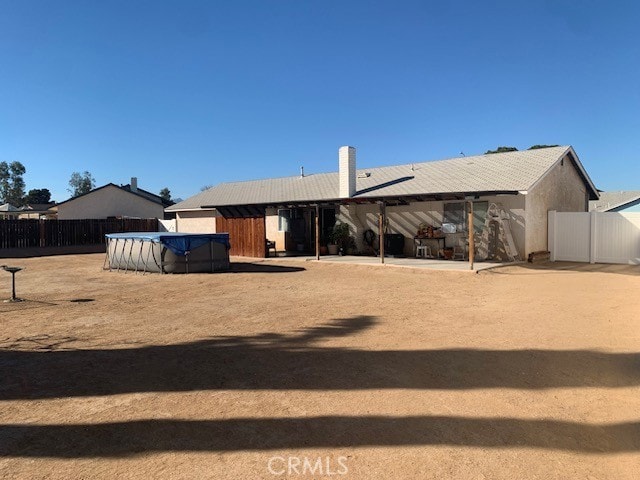 back of house with a patio and a covered pool