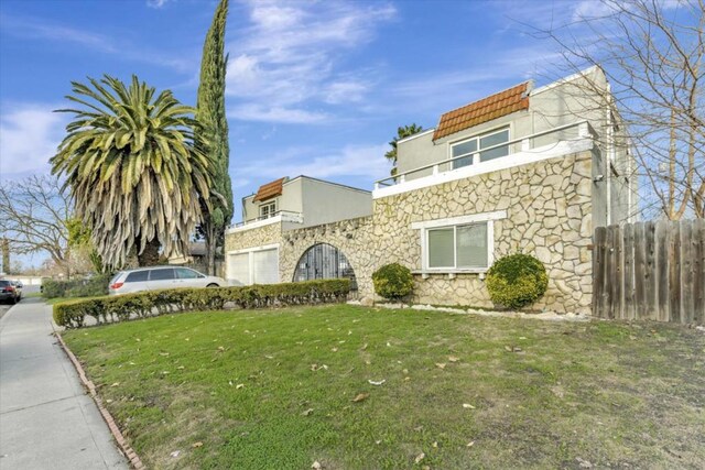 view of front of property with a balcony and a front yard