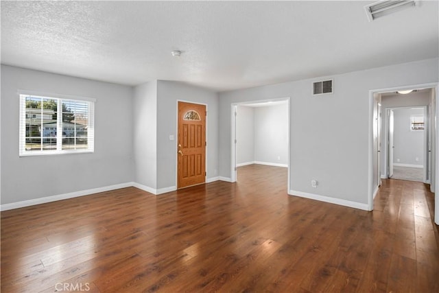 interior space with dark wood-type flooring and a textured ceiling