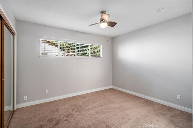 unfurnished bedroom with ceiling fan, light carpet, and a closet