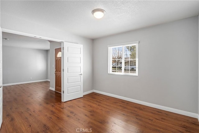 unfurnished room with dark hardwood / wood-style floors