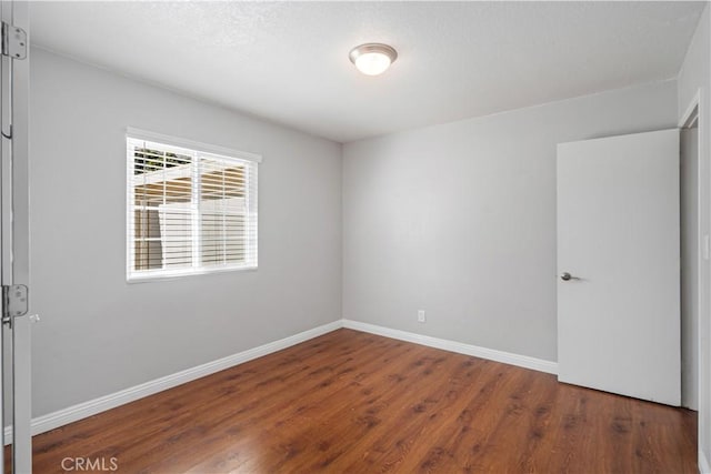 spare room with dark hardwood / wood-style flooring