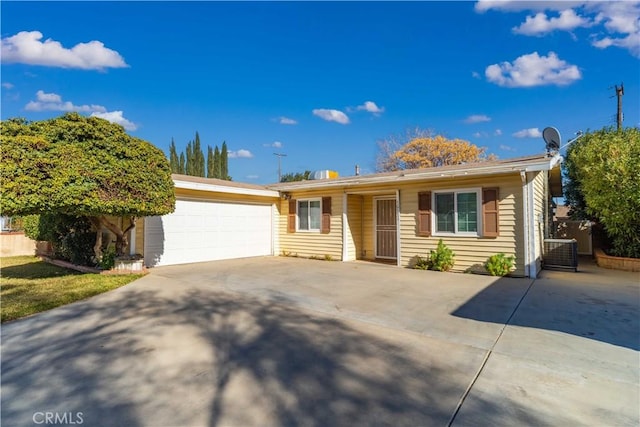 single story home with central AC unit and a garage