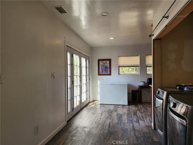 interior space featuring dark hardwood / wood-style floors, washer and clothes dryer, and french doors