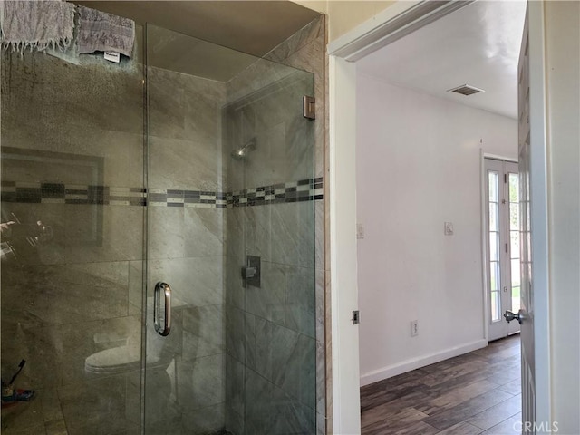 bathroom featuring wood-type flooring, toilet, and walk in shower