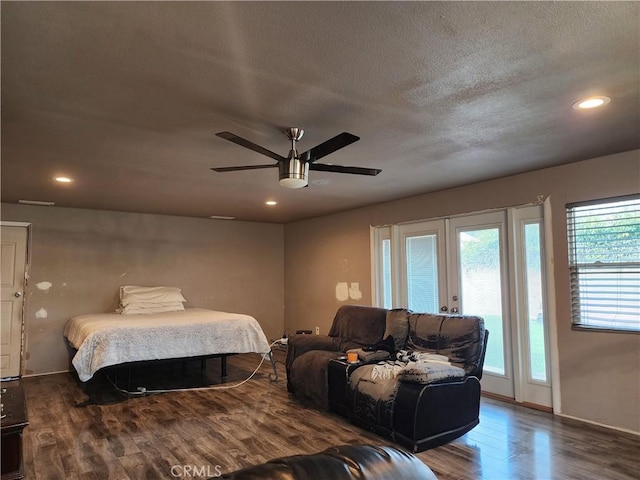 bedroom featuring dark hardwood / wood-style flooring, access to exterior, ceiling fan, a textured ceiling, and french doors