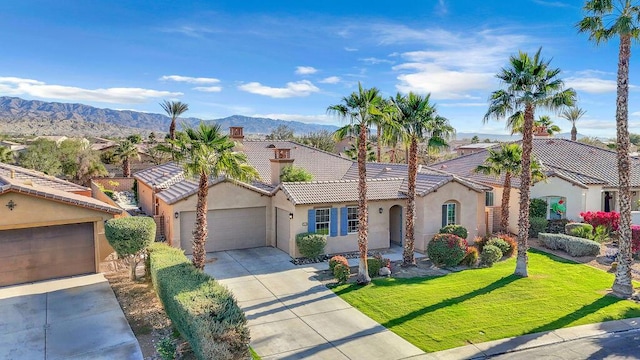 view of front of house featuring a front lawn, a mountain view, and a garage