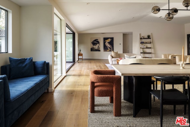 dining area featuring light wood-type flooring and lofted ceiling