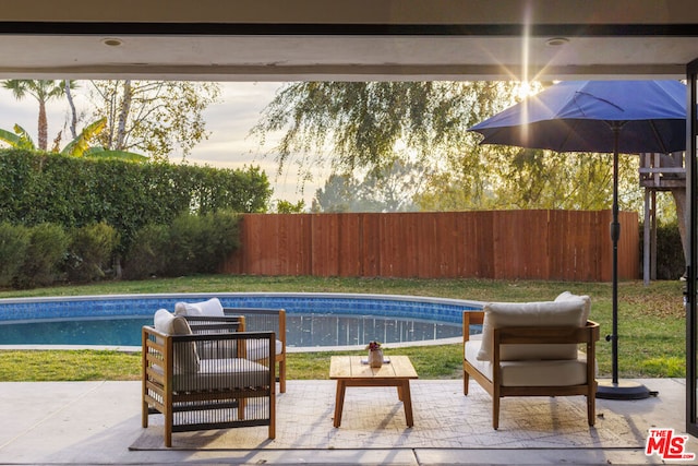 pool at dusk featuring a patio area