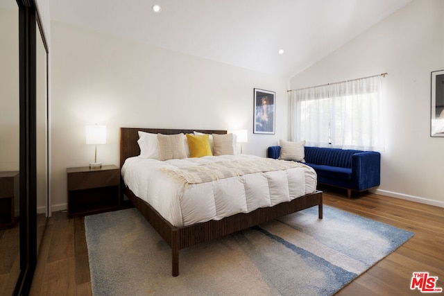 bedroom with vaulted ceiling and hardwood / wood-style floors