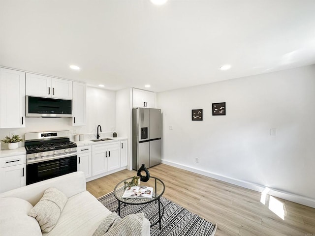 living room featuring sink and light hardwood / wood-style flooring