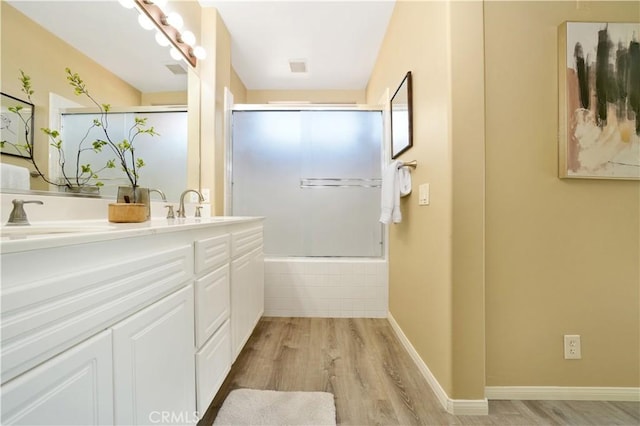 bathroom featuring wood-type flooring, walk in shower, and vanity