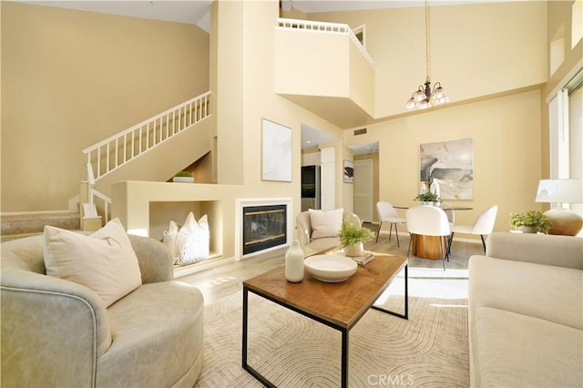 living room featuring an inviting chandelier and a towering ceiling