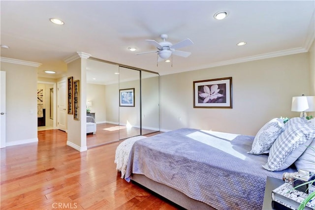 bedroom featuring ceiling fan, wood-type flooring, a closet, and ornamental molding