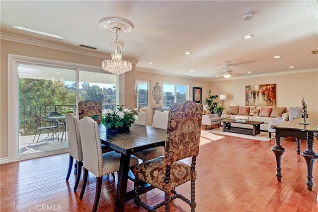 dining space featuring ceiling fan with notable chandelier, hardwood / wood-style floors, and ornamental molding