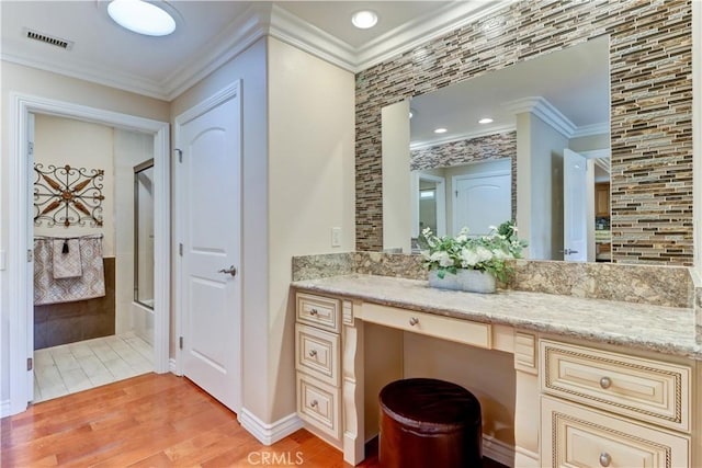 bathroom featuring vanity, wood-type flooring, crown molding, and enclosed tub / shower combo