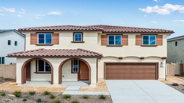 mediterranean / spanish home featuring stucco siding, a porch, concrete driveway, and a garage