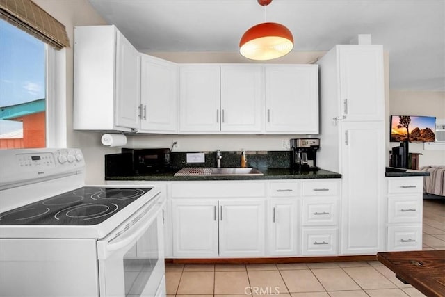 kitchen featuring white range with electric cooktop, sink, light tile patterned floors, and white cabinetry