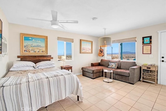 bedroom featuring ceiling fan, multiple windows, and light tile patterned flooring