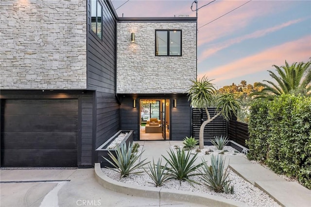 exterior entry at dusk with a garage