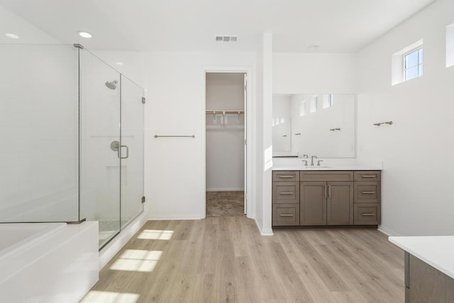 bathroom with vanity, plus walk in shower, and hardwood / wood-style floors