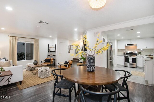 dining area featuring crown molding and hardwood / wood-style flooring