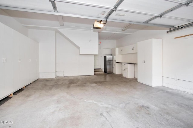 garage featuring a garage door opener and stainless steel refrigerator