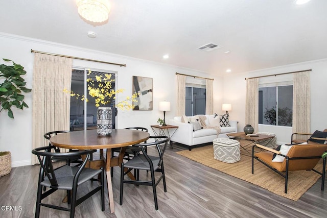 dining room with crown molding and hardwood / wood-style floors