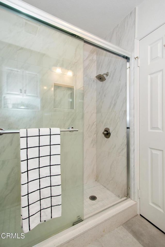 bathroom with tile patterned floors and a shower with door