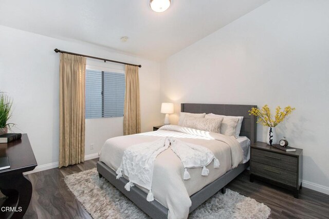 bedroom featuring lofted ceiling and dark hardwood / wood-style flooring