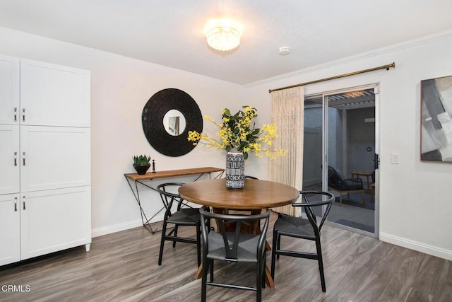 dining area with dark hardwood / wood-style flooring and ornamental molding