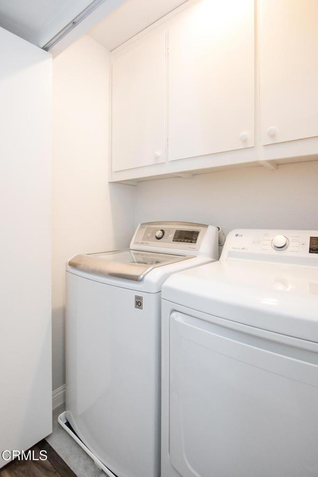 laundry room featuring cabinets, washer and clothes dryer, and dark hardwood / wood-style floors