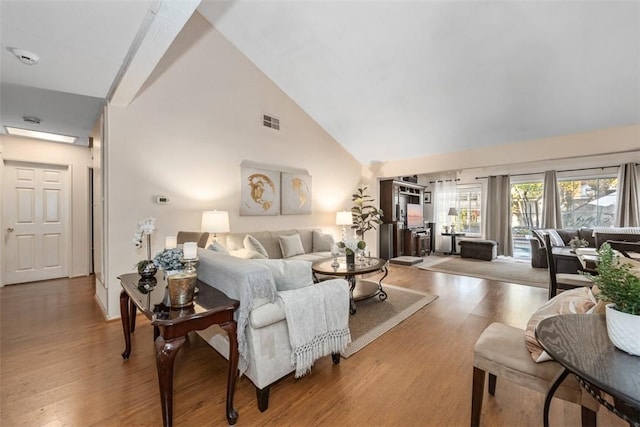 living room featuring high vaulted ceiling and wood-type flooring