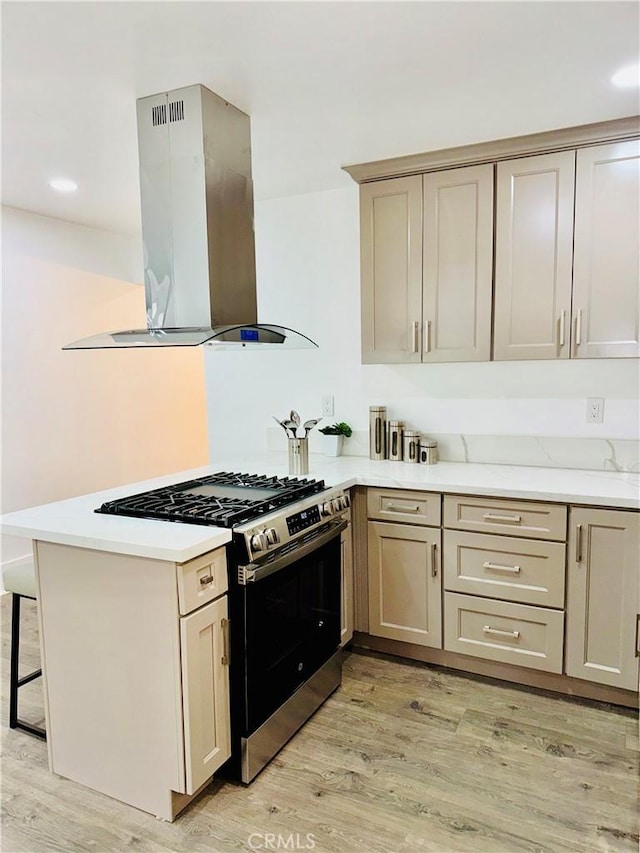 5737 5th, Los Angeles, CA 90043 - kitchen featuring range hood, stainless steel range with gas cooktop, a peninsula, light wood finished floors, and a breakfast bar
