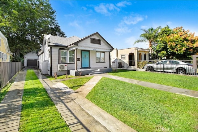 bungalow-style house featuring a front yard, an outbuilding, and a garage