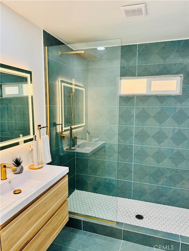 bathroom featuring tiled shower, vanity, and tile patterned flooring